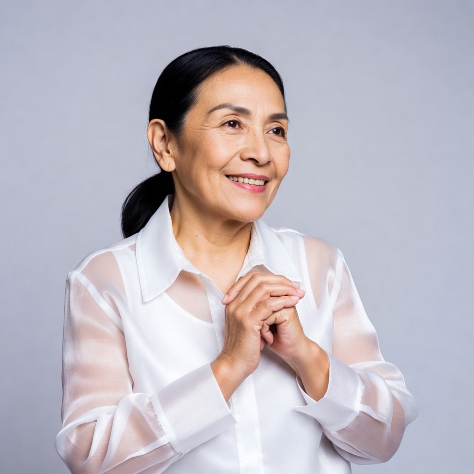 Asian woman smiling with hands clasped Asian woman smiling with hands clasped