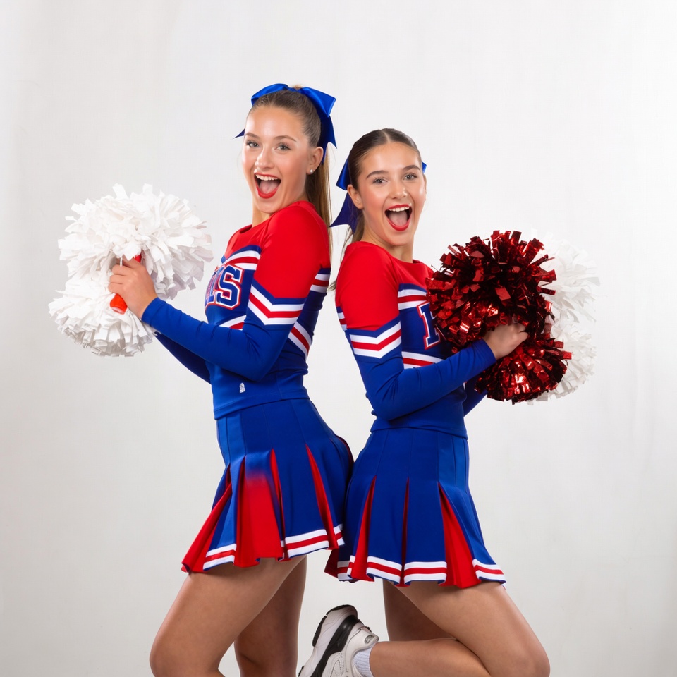 Two cheerful girls in cheerleader uniforms Two cheerful girls in cheerleader uniforms