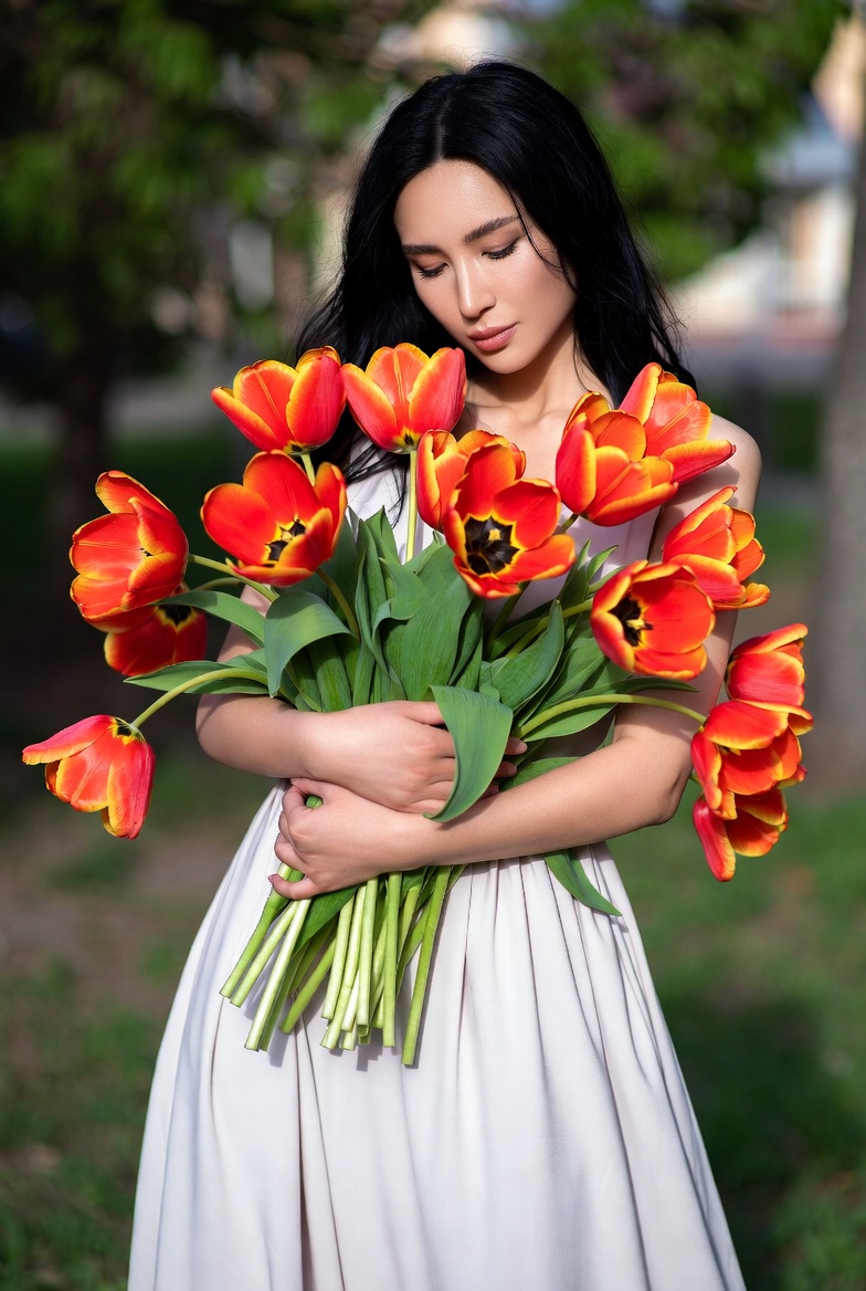 Asian woman holding red tulips Asian woman holding red tulips