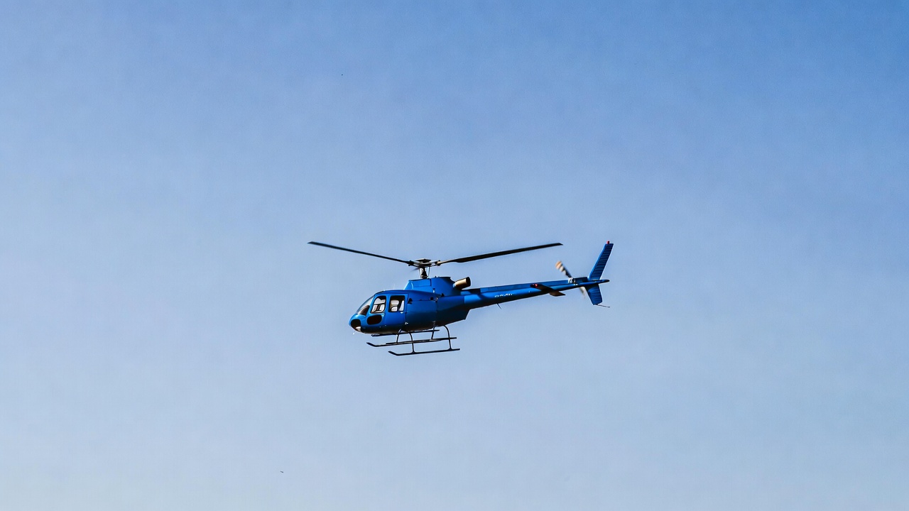 Blue helicopter flying in sky Blue helicopter flying in sky