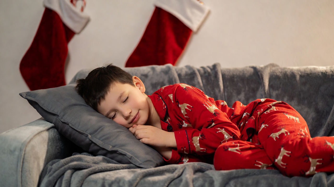 Boy sleeping in reindeer pajamas on couch Boy sleeping in reindeer pajamas on couch
