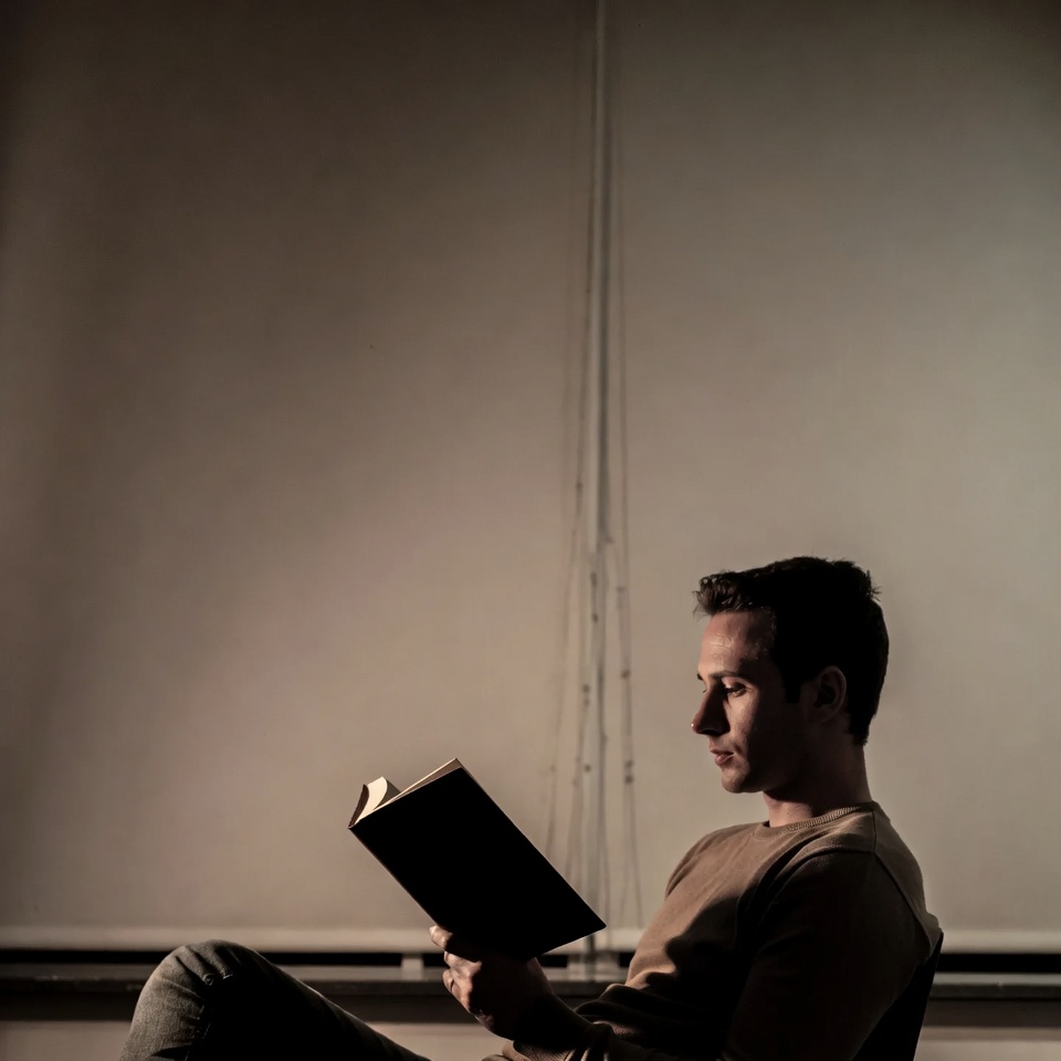 Man reading book by window Man reading book by window