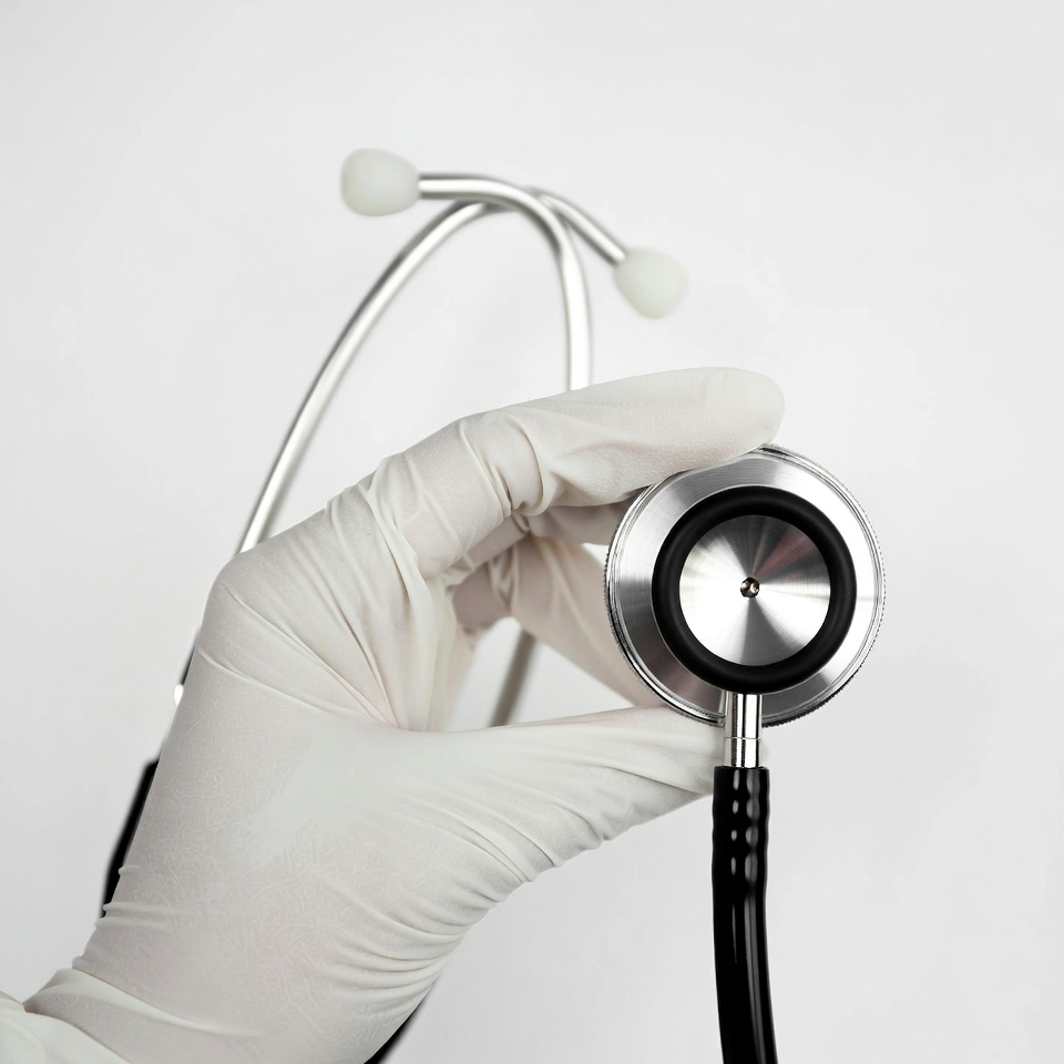 Gloved hand holding stethoscope Gloved hand holding stethoscope