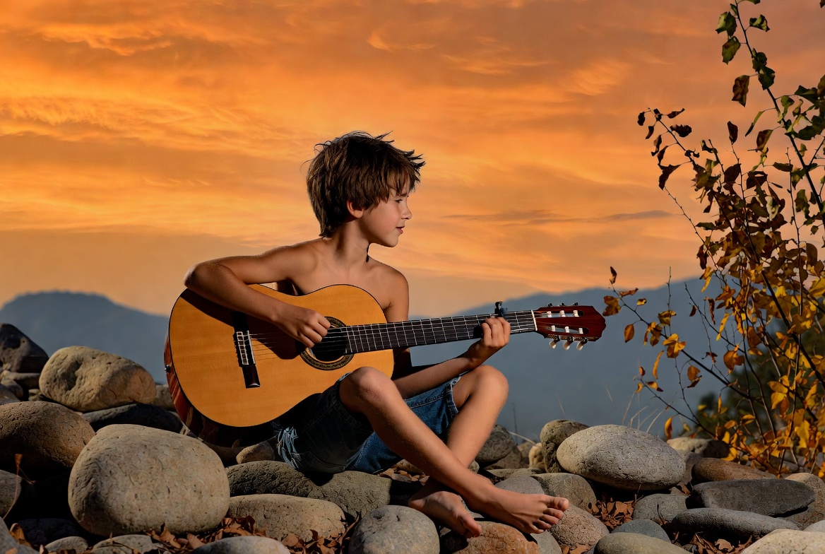 Boy playing guitar at sunset Boy playing guitar at sunset
