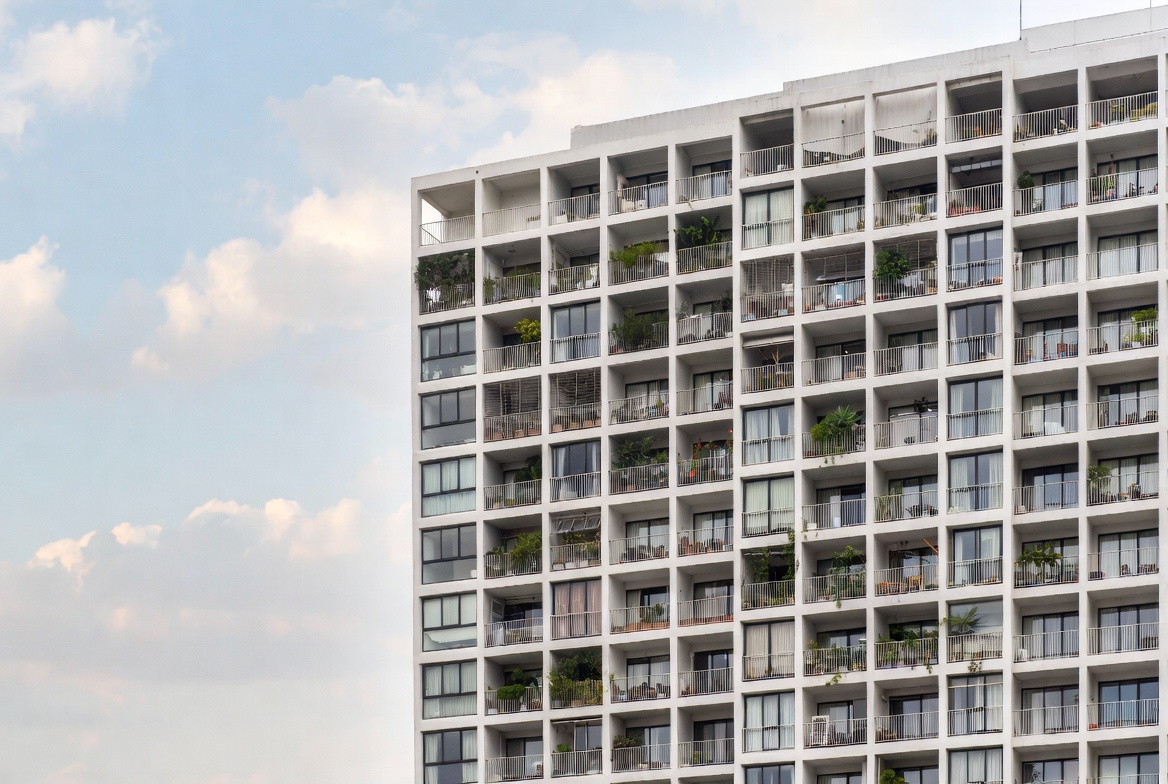 Modern high-rise building with balcony plants Modern high-rise building with balcony plants