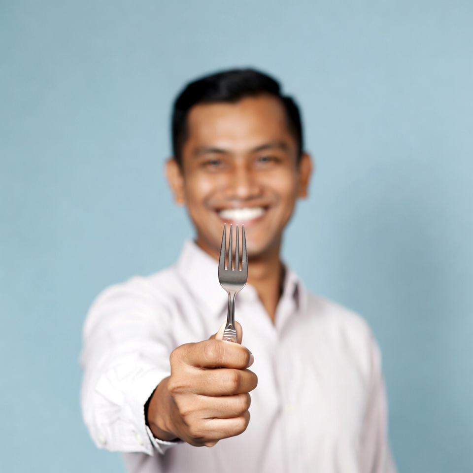 Asian man holding fork Asian man holding fork