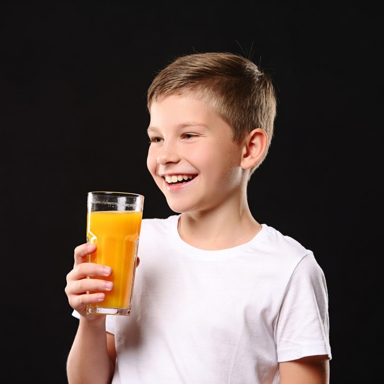 Boy holding glass of orange juice Boy holding glass of orange juice