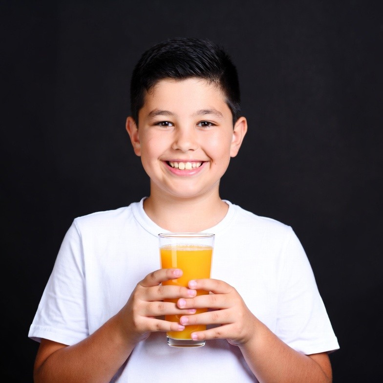 Boy holding glass of orange juice Boy holding glass of orange juice