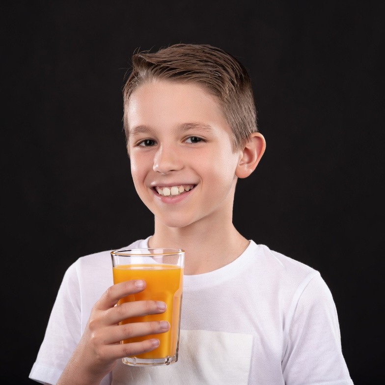 Boy holding orange juice glass Boy holding orange juice glass