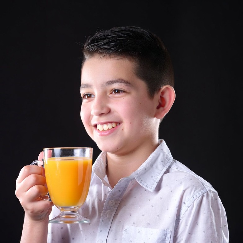Boy holding glass of orange juice Boy holding glass of orange juice