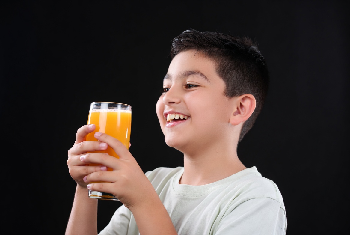 Boy smiling with orange juice glass Boy smiling with orange juice glass