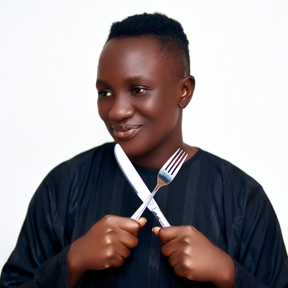 African woman holding crossed knife fork African woman holding crossed knife fork