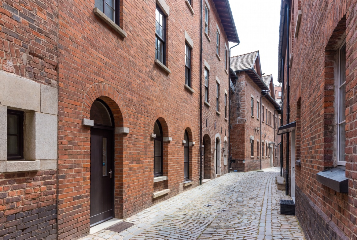 Narrow Cobblestone Alley Between Brick Buildings Narrow Cobblestone Alley Between Brick Buildings