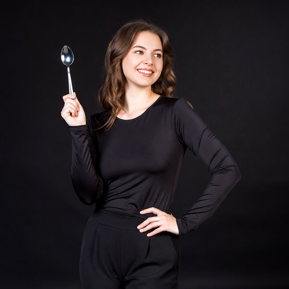 Woman holding spoon on black background Woman holding spoon on black background