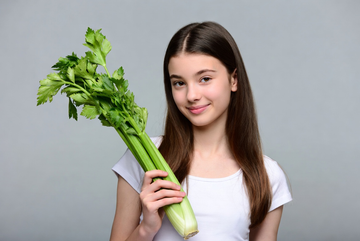 Girl holding fresh celery Girl holding fresh celery