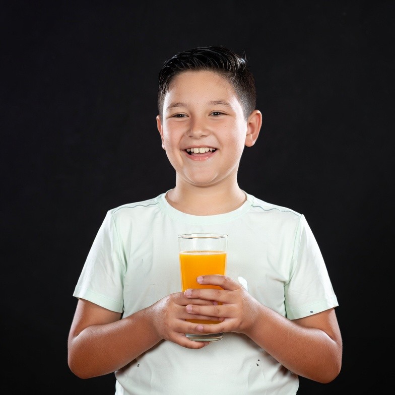 Boy holding glass of orange juice Boy holding glass of orange juice