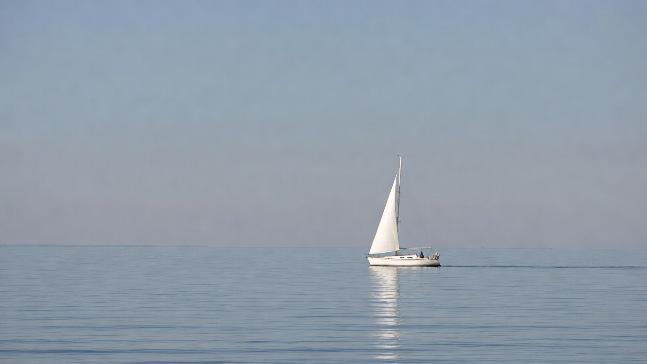 White sailboat on calm sea White sailboat on calm sea