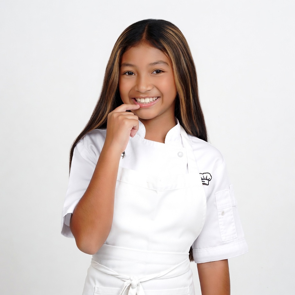 Asian girl chef smiling with finger on lips Asian girl chef smiling with finger on lips