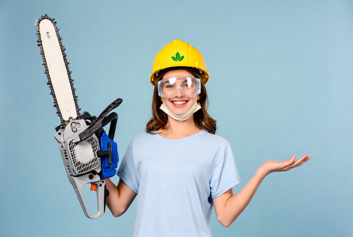 Woman holding chainsaw with helmet Woman holding chainsaw with helmet