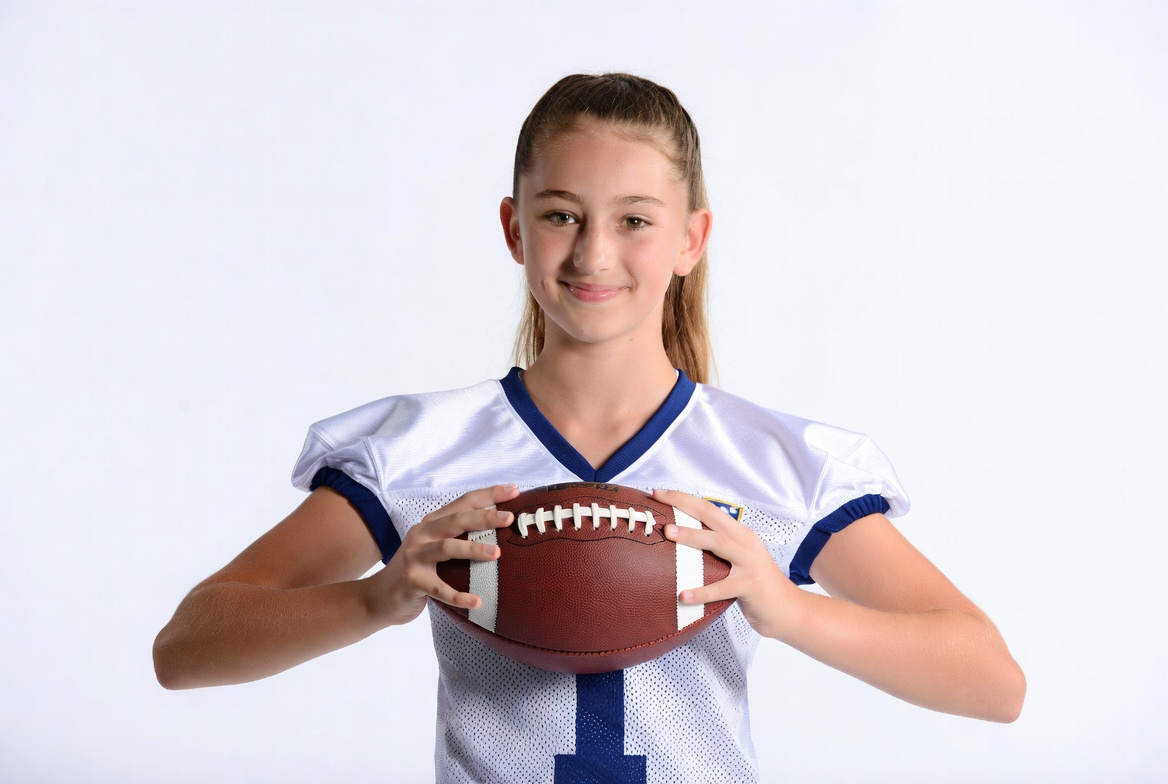 Girl holding football in jersey Girl holding football in jersey