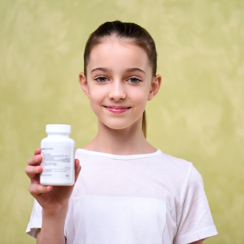 Girl holding white pill bottle Girl holding white pill bottle