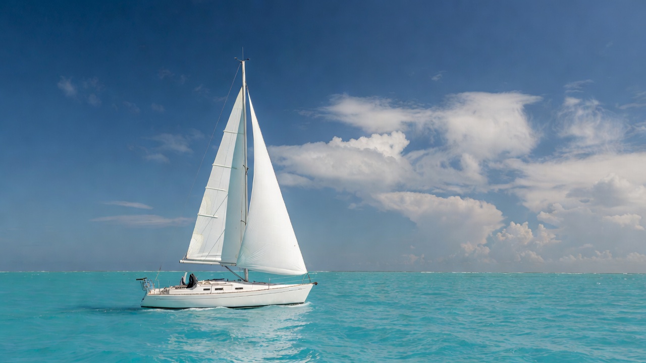 White sailboat on turquoise ocean White sailboat on turquoise ocean