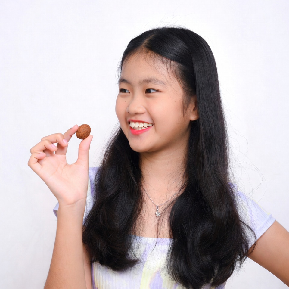 Asian girl holding small cookie Asian girl holding small cookie