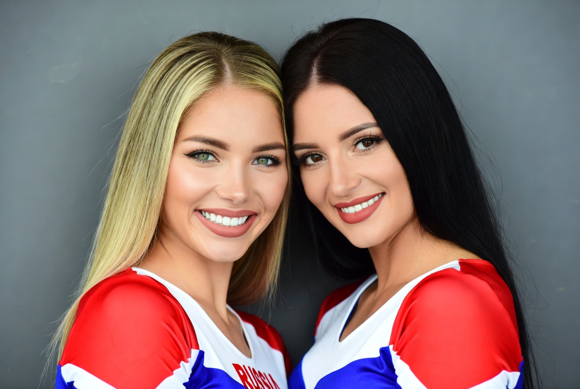 Two smiling cheerleaders in red white uniforms Two smiling cheerleaders in red white uniforms