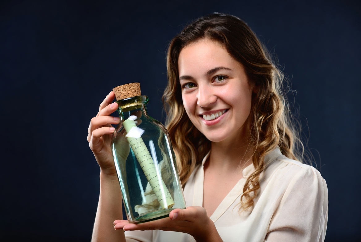 Woman holding message in bottle Woman holding message in bottle