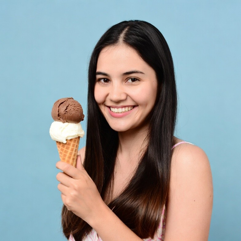 Young woman holding vanilla chocolate ice cream cone Young woman holding vanilla chocolate ice cream cone