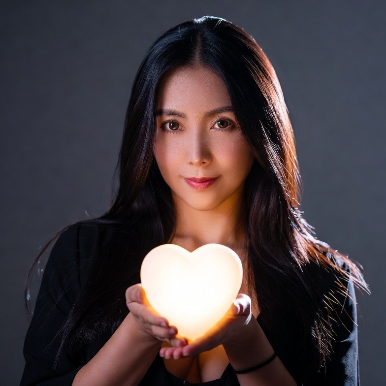 Asian woman holding glowing heart Asian woman holding glowing heart