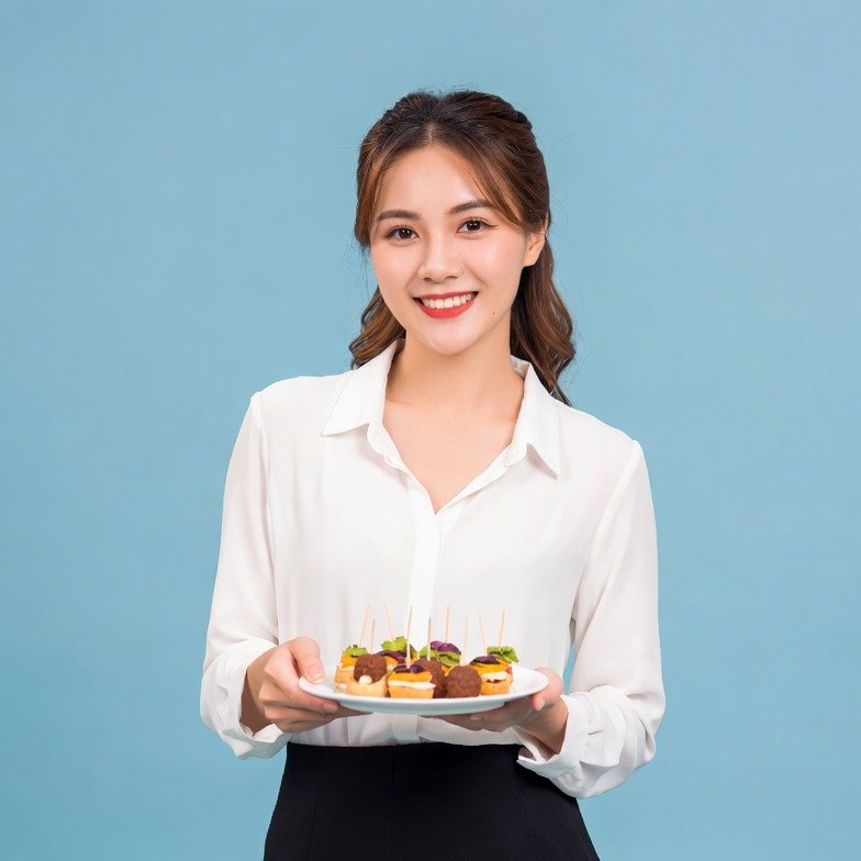 Asian woman holding skewers on plate Asian woman holding skewers on plate
