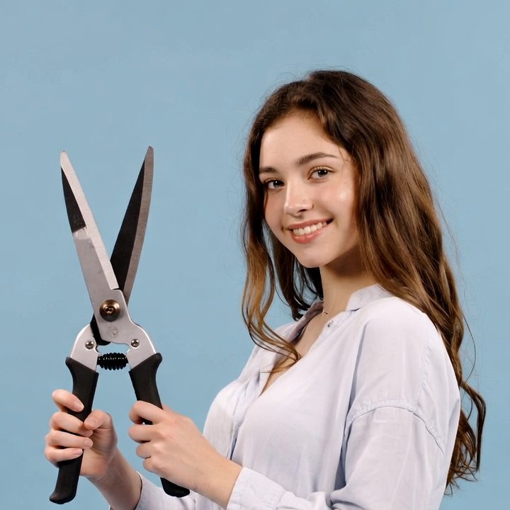 Young woman holding pruning shears Young woman holding pruning shears
