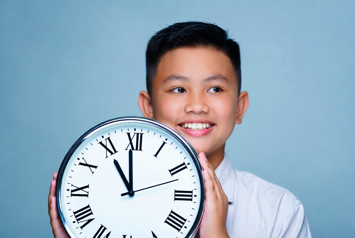 Asian boy holding large clock Asian boy holding large clock