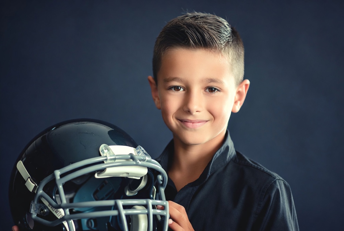Boy holding football helmet Boy holding football helmet