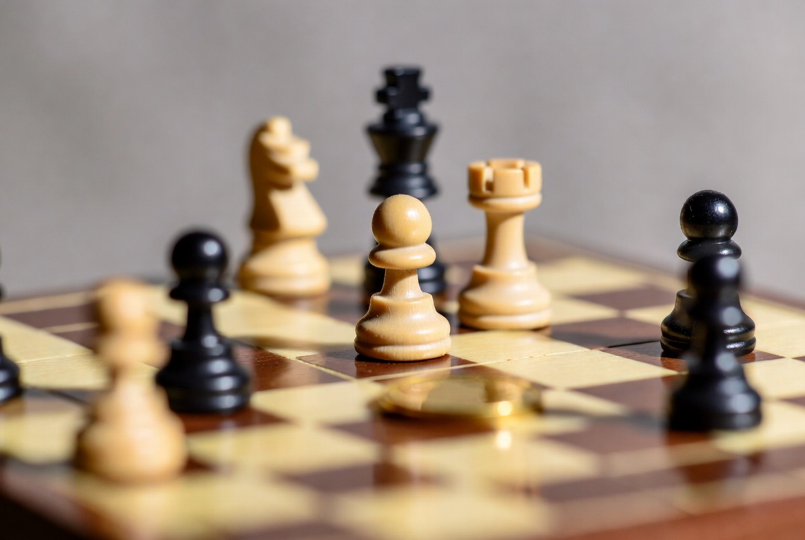 Chess board with pieces and gold coin Chess board with pieces and gold coin