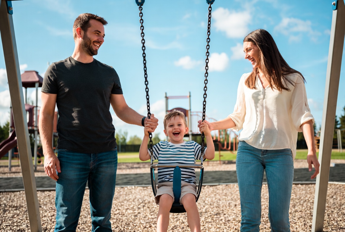 Parents pushing toddler on playground swing Parents pushing toddler on playground swing