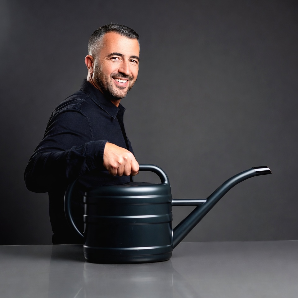 Man holding black watering can Man holding black watering can