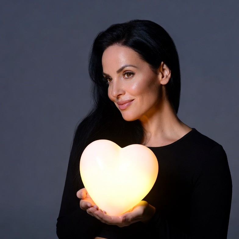 Woman holding glowing heart Woman holding glowing heart