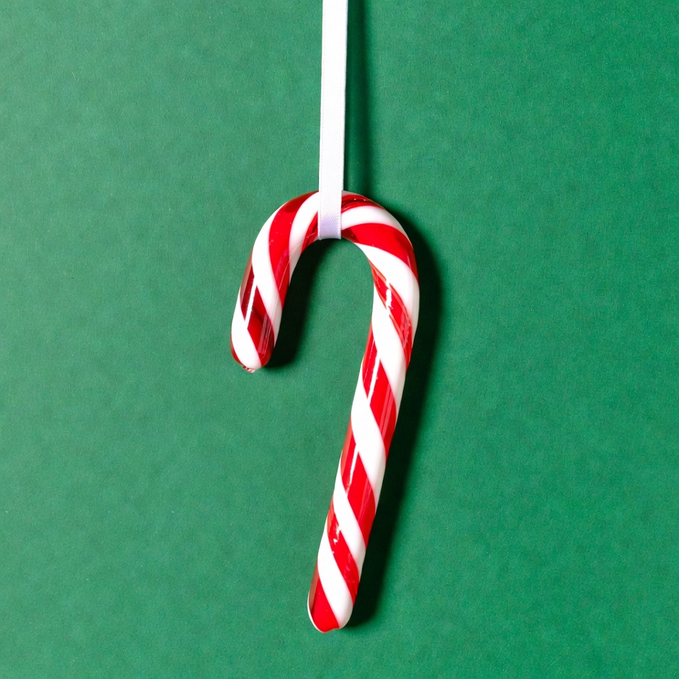 Candy cane hanging on green background Candy cane hanging on green background