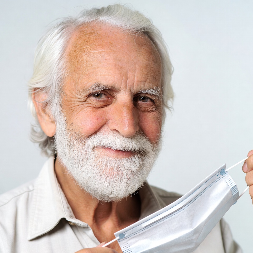Elderly man holding white mask Elderly man holding white mask