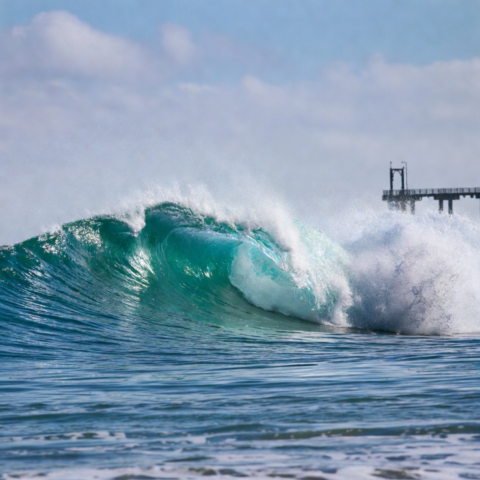 Massive green wave crashing near pier Massive green wave crashing near pier