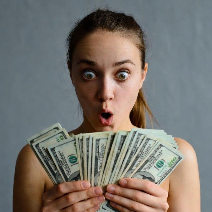 Surprised woman holding cash Surprised woman holding cash