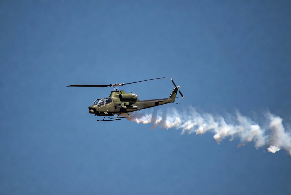 Military helicopter flying with smoke trail Military helicopter flying with smoke trail