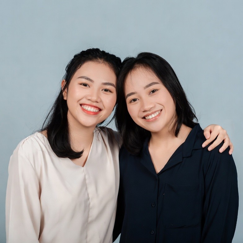 Two Asian women smiling together Two Asian women smiling together