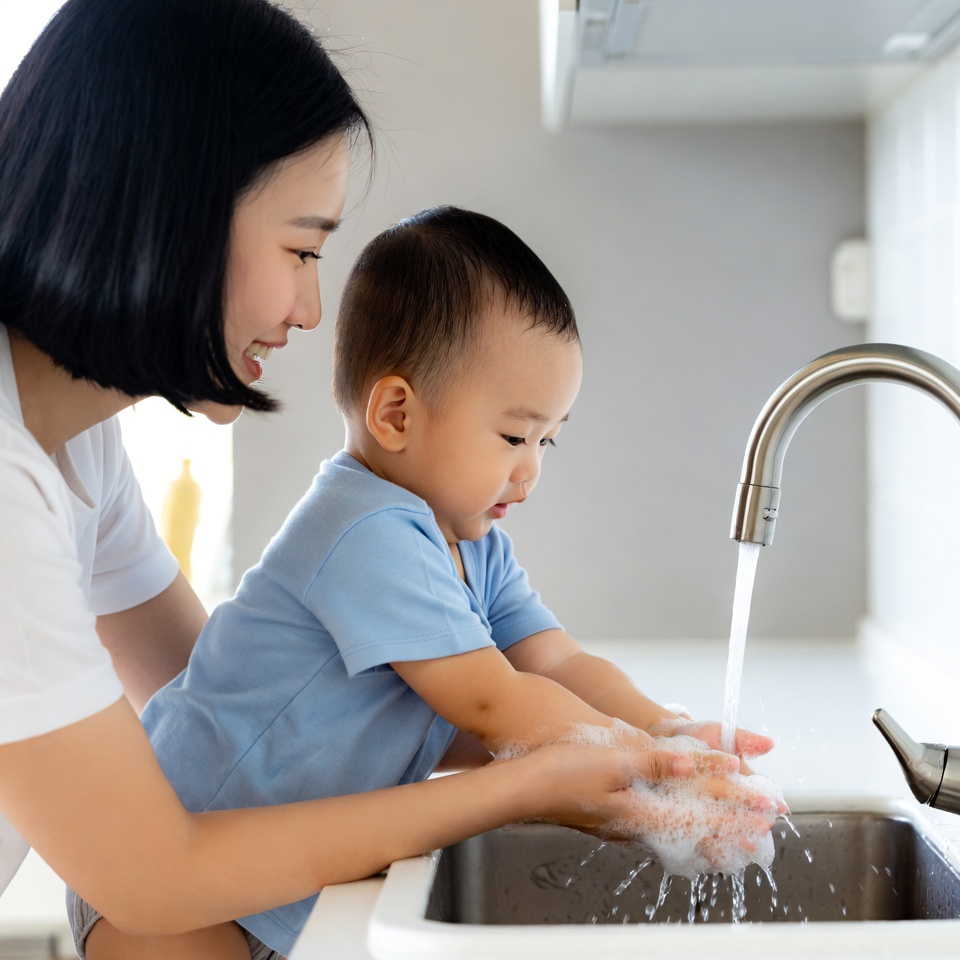 Asian mother teaching baby to wash hands Asian mother teaching baby to wash hands