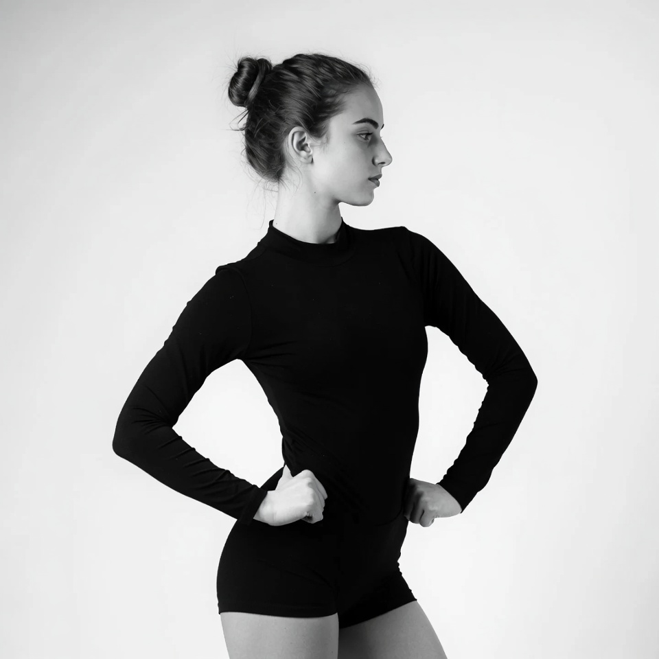 Young woman in black bodysuit profile pose Young woman in black bodysuit profile pose