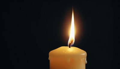 Single candle flame in darkness