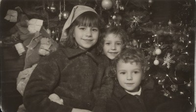 Three children by christmas tree