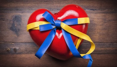Red heart with ukrainian colors on wood